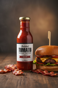 350 mL bottle of Twisted Tomato Bacon Ketchup beside a burger and pieces of bacon on a wooden table
